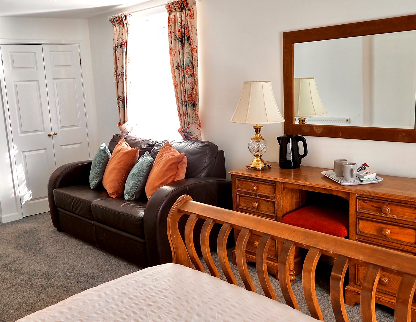 Double room with teal cushions and wall lights at The Normandie