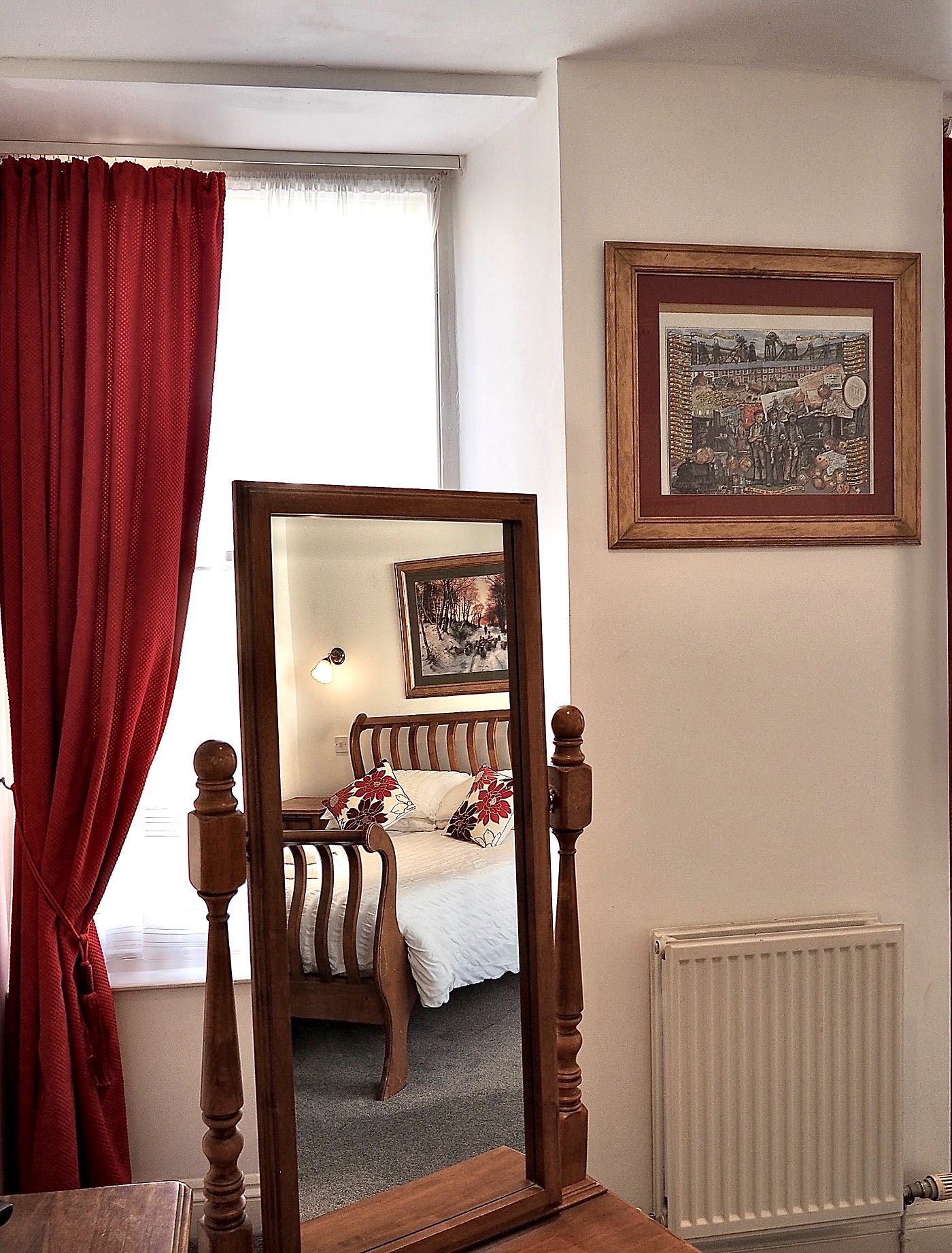 Period dressing mirror and red curtains in a Normandie bedroom